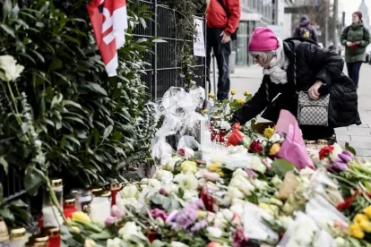 Una mujer deposita una flor en el lugar de luto tras la embestida de un coche contra una manifestación en Múnich