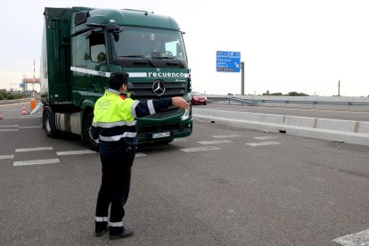 Un agent dels Mossos orienta un dels conductors aturats al control de l'AP-7 a Salou.