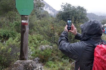 Un home fotografia una de les marques GR al sender que porta fins a l'ermita de Sant Blai a Tivissa