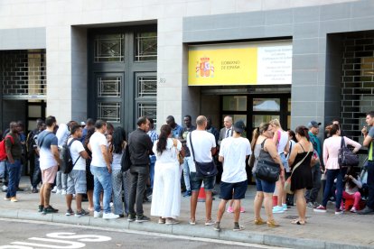 Desenes de persones fan cua a les portes de l'Oficina d'Estrangeria del Passeig de Sant Joan.