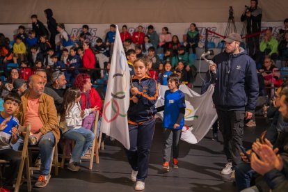 Una de les capitanes d’una escola portant la bandera olímpica cap a l’escenari.