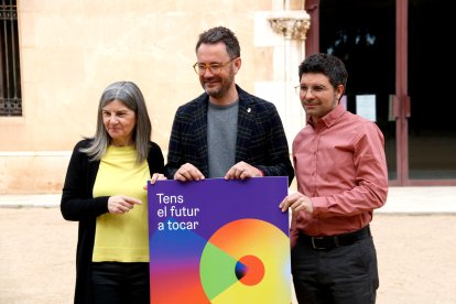 La regidora de Cultura de Vila-seca, Manuela Moya, l'alcalde Pere Segura i el director artístic de la FiM, Martí Marfà, amb el cartell de l'edició d'enguany.