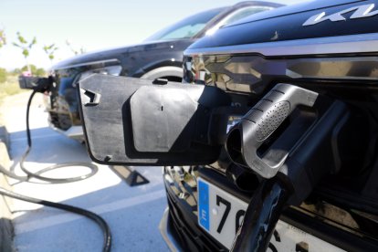 Un vehicle elèctric endollat i un altre al fons també carregant-se a una àrea de servei de Fonollers