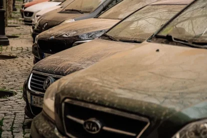 Imagen de varios coches llenos de barro tras el paso de una lluvia de sangre.