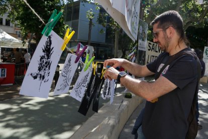 Un home penja una estampació d'una fulla coincidint amb el 40è aniversari de Gepec-EdC a Reus