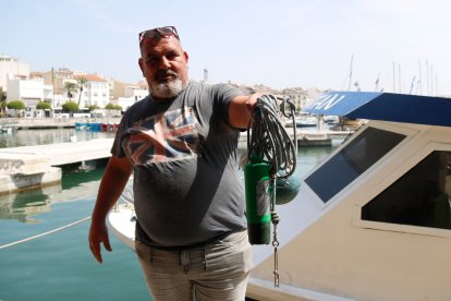 Un pescador de Cambrils sosté el dispositiu auditiu per allunyar els dofins.