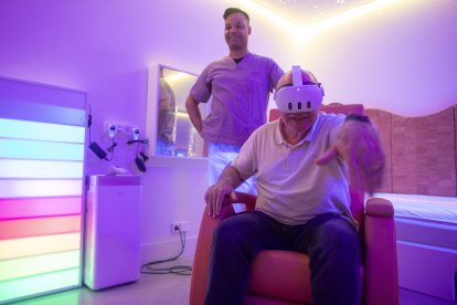 Un usuari, fent ús de les ulleres de la realitat virtual, amb l’acompanyament del neuropsicòleg Cristian Cabrera.