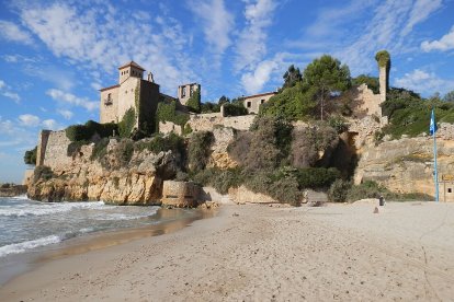 Imatge de la platja de Tamarit amb el castell de fons.