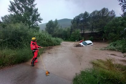 Els Bombers retirant un cotxe que s'ha emportat l'aigua al riu Cardener, a Súria