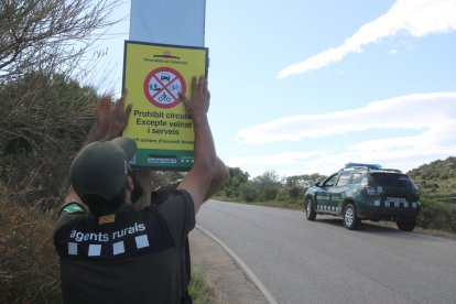 Dos agents rurals col·locant el cartell de prohibit el pas al Cap de Creus