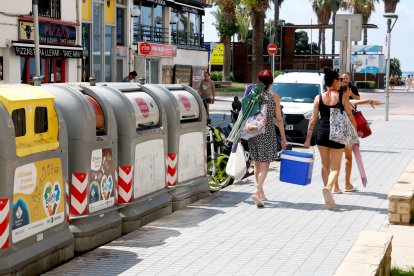 Dues dones passen pel costat dels contenidors mentre van a la platja a Salou.