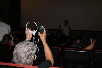 Un home mostra un micròfon de corbata i uns auriculars durant el taller de so cinematogràfic inclòs al programa d'In-FCTA