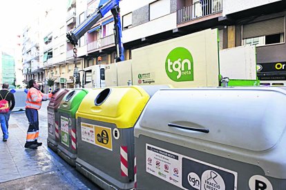 Imatge d’arxiu d’un treballador de la neteja manipulant uns contenidors.