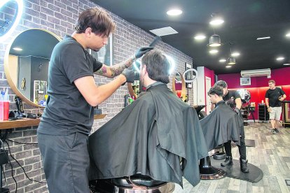 Imatge d’una de les barberies amb més públic de la ciutat, amb clients habitualment joves.
