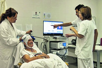 Vicenç Pascual, coordinador del servei de Neurofisiologia Clínica de l’HUSJR, junt amb una pacient que se sotmet a la teràpia pel dolor crònic.