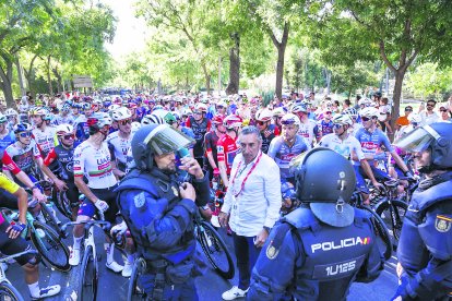 Imatge dels antiavalots de la Policia Nacional davant dels ciclistes en la darrera etapa de la Vuelta a Madrid.