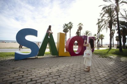 Una turista fent una foto a les lletres de Salou