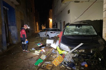 Un bomber en una de les actuacions, amb cotxes i residus acumulats a Godall.