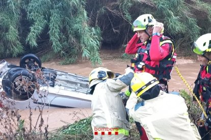 Efectius dels Bombers treballen per recuperar un cotxe sense ocupants arrossegat pel riu Ripoll a Sabadell