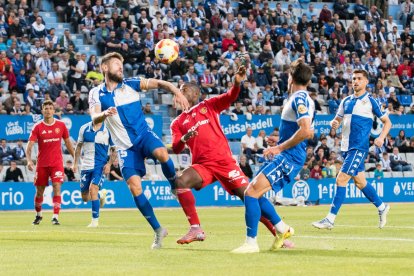 El jugador del Nàstic, Cedric Omoigui, intentant guanyar la pilota contra els centrals del Sabadell.