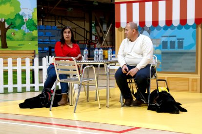 Dues persones cegues amb els seus gossos pigall a l'exhibició de Reus