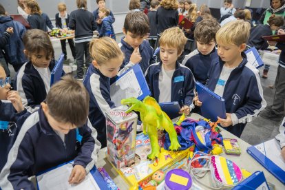 Fotografia d’alumnes de l’Escola Maria Cortina observant els objectes portats per altres nens al Mercat de Bescanvi Escolar.
