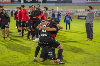 A l’esquerra, els jugadors del Reus celebrant amb eufòria la victòria contra l’Europa i, a la dreta, el tècnic Marc Carrasco