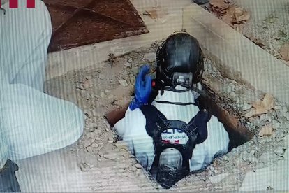 Agents de mossos entrant a la fossa sèptica on han trobat un cos.