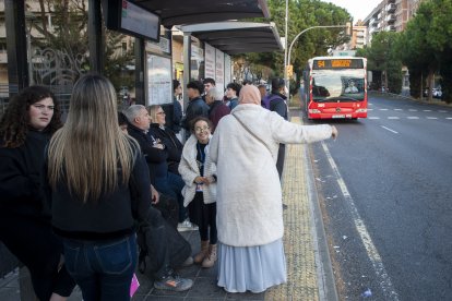 Imatge de diverses persones esperant el 54 a l'avinguda Roma.