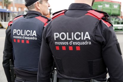 Esquena de dos agents dels Mossos d'Esquadra patrullant