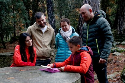 Diversos familiars de l'Anna observen les il·lustracions que va fer.