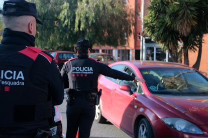 Dos agents dels Mossos d'Esquadra aturen un cotxe a l'entrada del barri de Sant Josep Obrer de Reus durant l'operatiu Kanpai