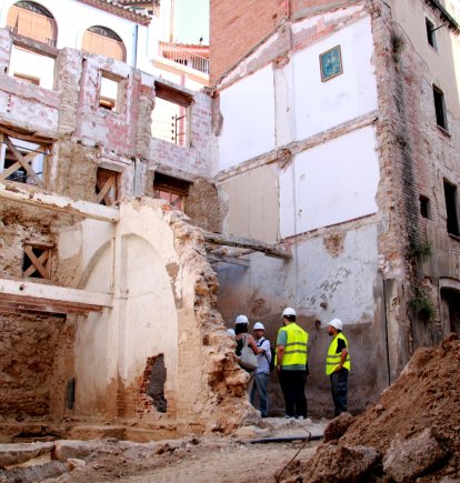 Diversos operaris i els arquitectes a la zona on s'està restaurant la muralla medieval de Sant Francesc de Valls