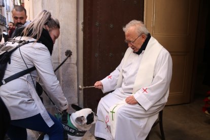 Un capellà beneeix un gos durant la festivitat dels Tres Tombs de Valls