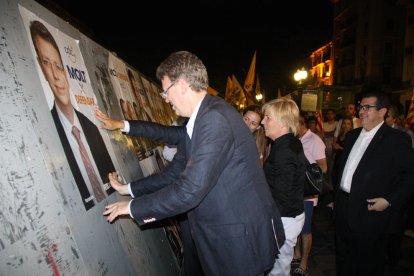 El cap de llista de CDC per Tarragona, Ferran Bel, enganxant un cartell electoral, amb el conseller Jordi Jané al seu darrere. Imatge del 10 de juny del 2016