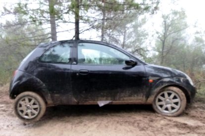 Un turismo, atrapado en el barro, atravesado en un camino de acceso a la fiesta.