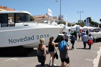 Visitants passejant entre les embarcacions exposades al passeig marítim de Cambrils, en el marc de la fira nàutica, el 16 de maig de 2016