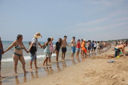 Un centenar de veïns s'uneixen en una cadena humana per reclamar més protecció per la Platja Llarga