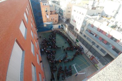 Els alumnes del Col·legi El Carme formen la figura d'un colom pel dia escolar de la no-violència