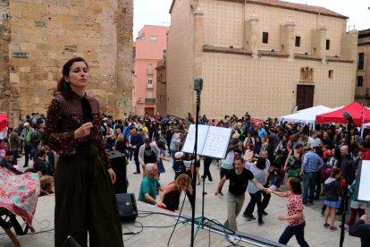 Pla general d'una dona cantant amb parelles de swing ballant a la plaça del Rei de Tarragona en una de les actuacions musicals del Dixieland.