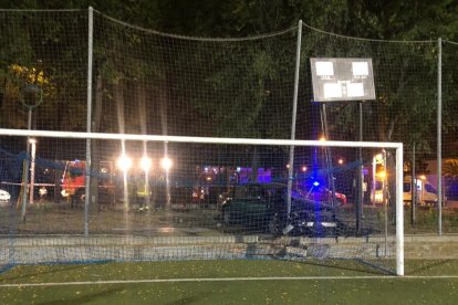 Imagen del coche estampado contra un pequeño muro y la red del campo.