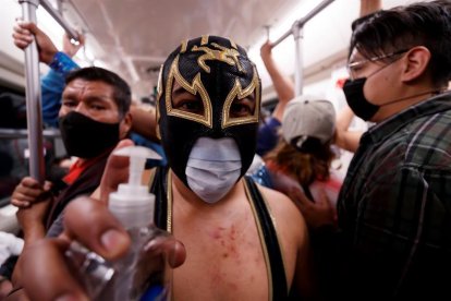 Mascaretes a la força: lluitadors mexicans les reparteixen al metro