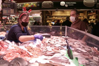 Una peixatera atenen un comprador en una parada del Mercat Central de Tarragona pocs dies abans de Nadal.