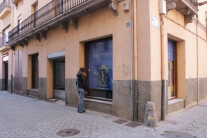 Una persona mirando uno de los cristales rotos de la sede de Aliança Catalana en Ripoll
