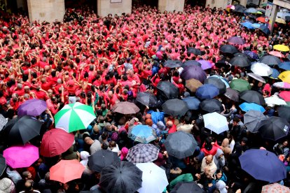 El púbic es protegeix de la pluja amb paraigues darrera les dues colles de Valls