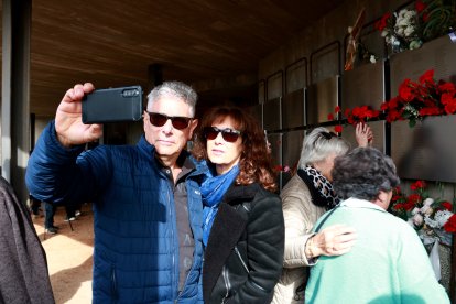 Una parella es fotografia davant les plaques on es recorden els combatents de la batalla de l'Ebre