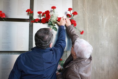 La Magda García, veïna de Viladecans, col·loca un clavell a la placa on es recorda el seu pare, un dels combatents de la batalla de l'Ebre