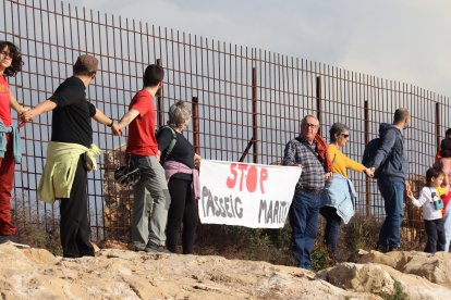 Una parella aguantant una pancarta on es demana que s'aturi el passeig marítim