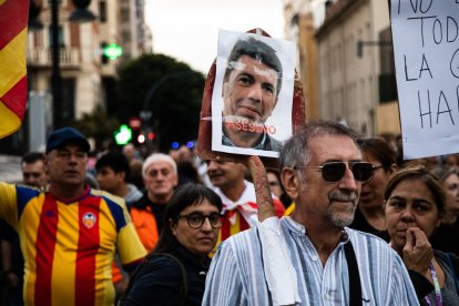 Un manifestante lleva una pala con una fotografía del presidente de la Generalitat Valenciana, Carlos Mazón, y el texto 'Asesino'