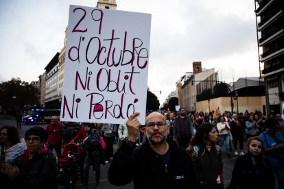 Un manifestante sostiene un letrero con el texto '29 de octubre, ni olvido ni perdón'
